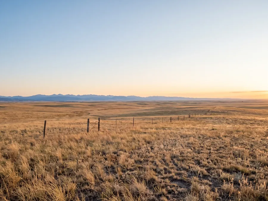 Open prairie west of Cheyenne under a wide sky, with the mountains on the horizon.